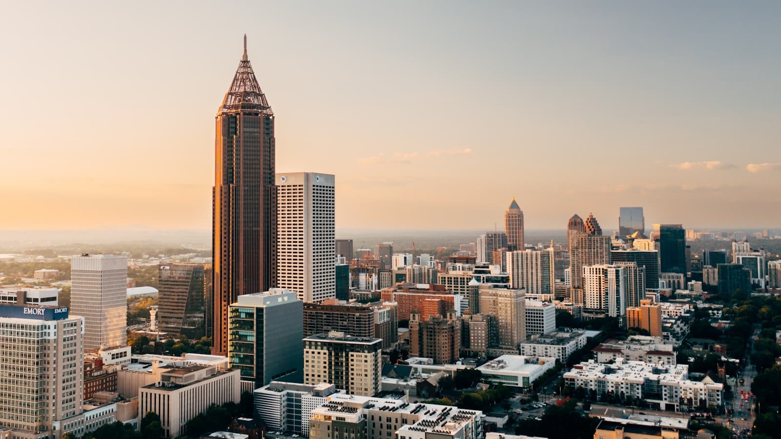 Aerial view of Atlanta downtown skyline at sunset with tall cylindrical tower and modern skyscrapers